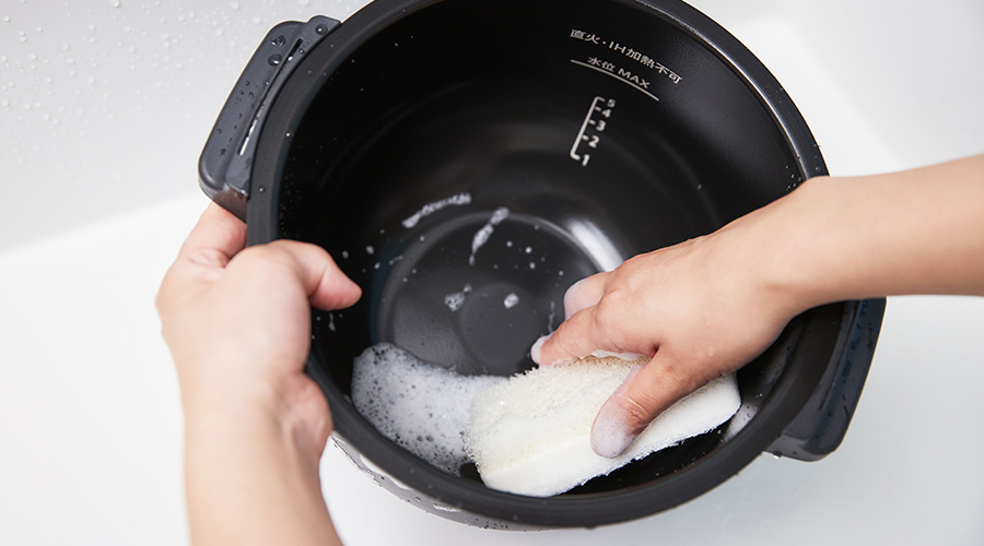 ホットクックの内鍋を外してスポンジで洗う手元